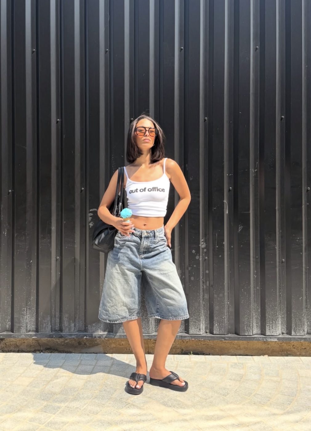 Kahina Tahri, talent OMNY Agency, style urbain devant un mur métallique